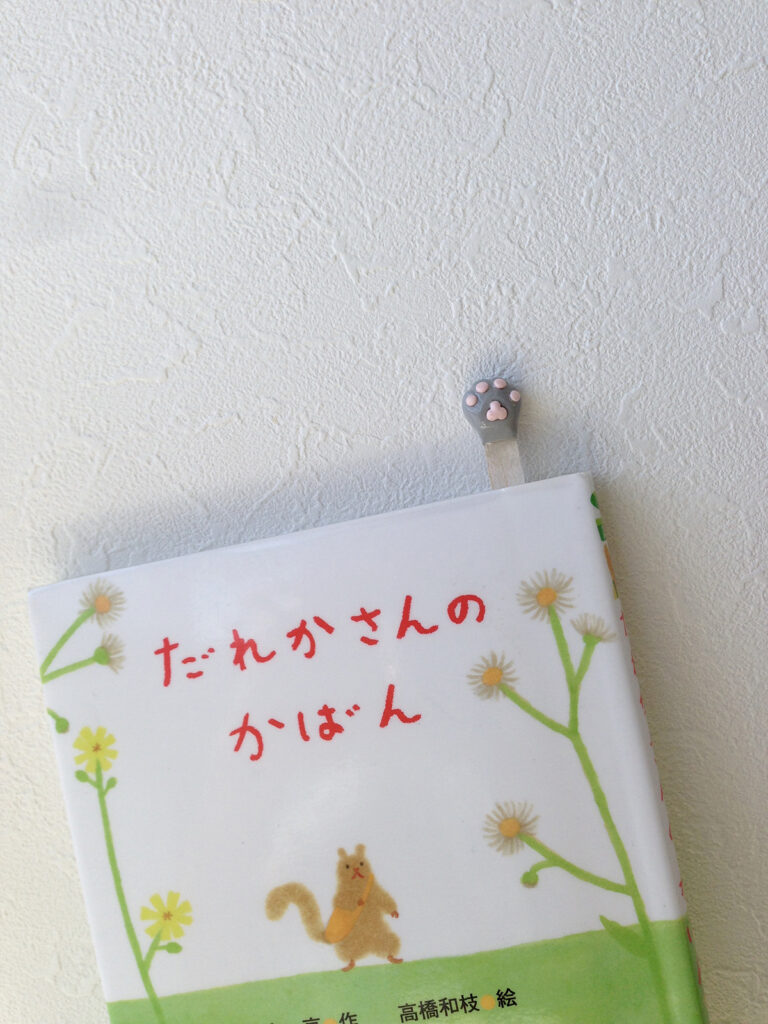 手作りの猫の手しおりが挟まっている書籍