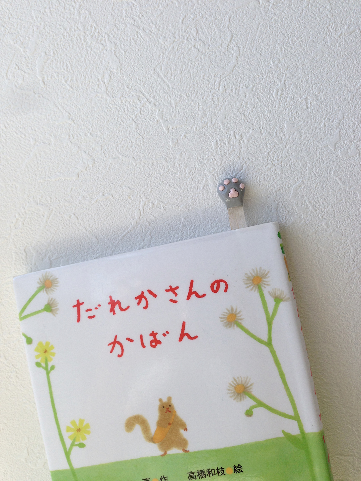 手作りの猫の手しおりが挟まっている書籍